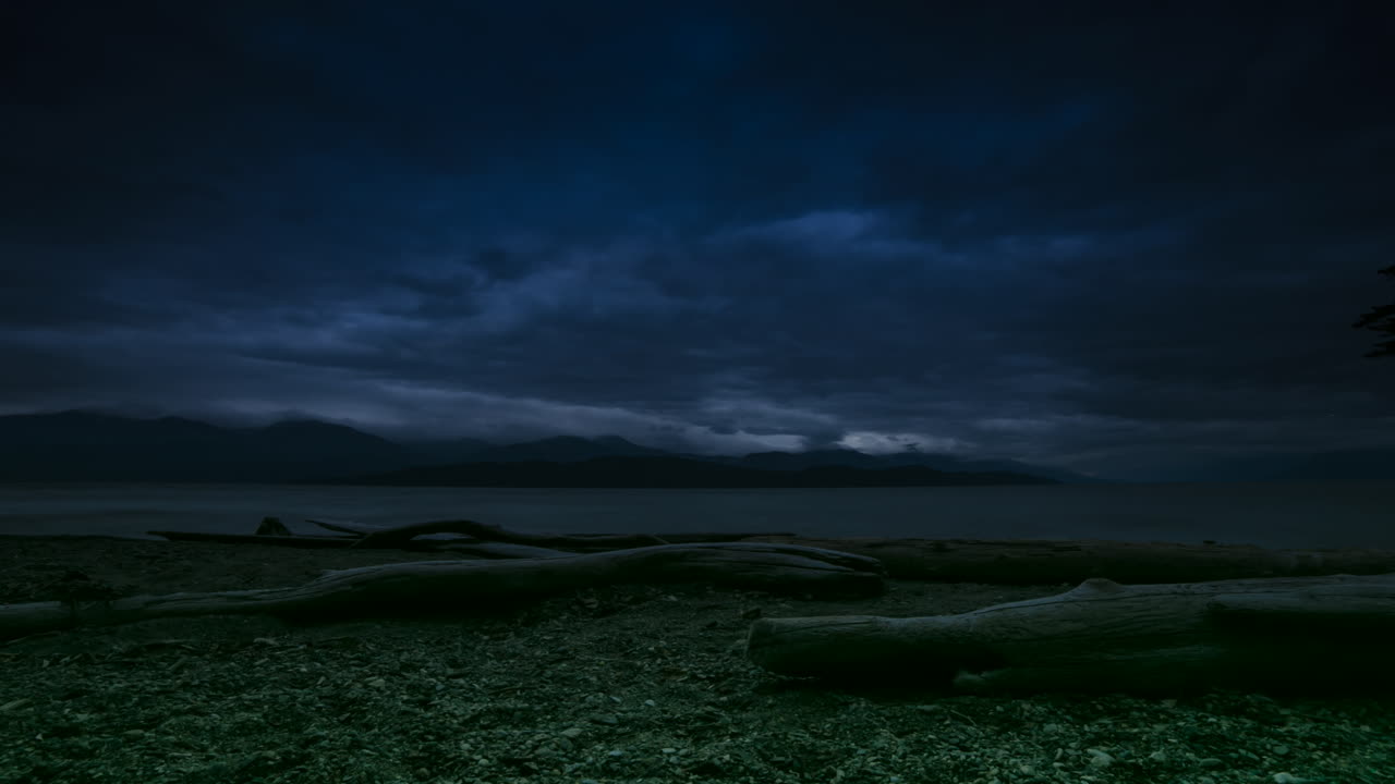 Timelapse av strandstockar och strömmande moln som övergår till kväll