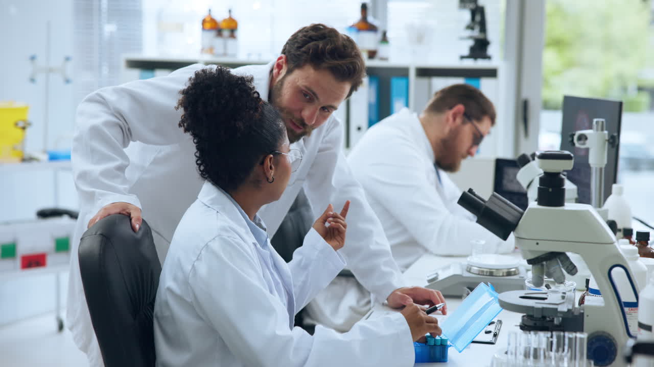 Científicos colaborando y hablando sobre investigación en un laboratorio moderno