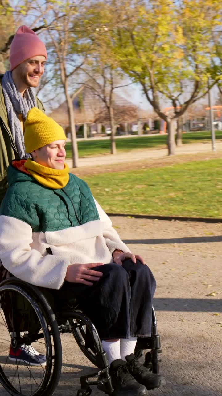 People enjoying a sunny day in the park with wheelchair assistance