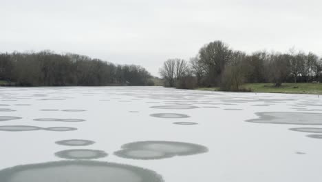 drone aerial footage of a 4k drone flying very close over a frozen lake in germany