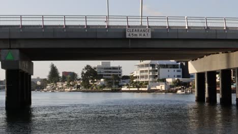 boat travels under bridge on a river