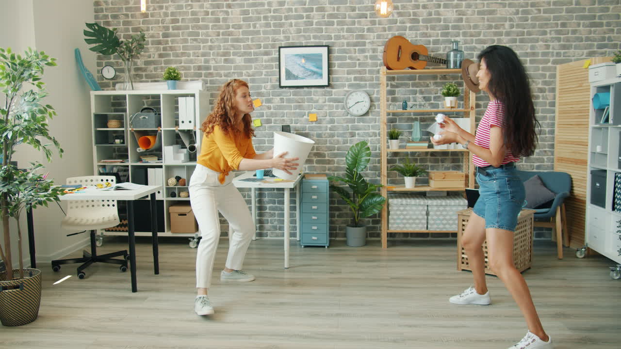 Two women playing a game in a modern office space