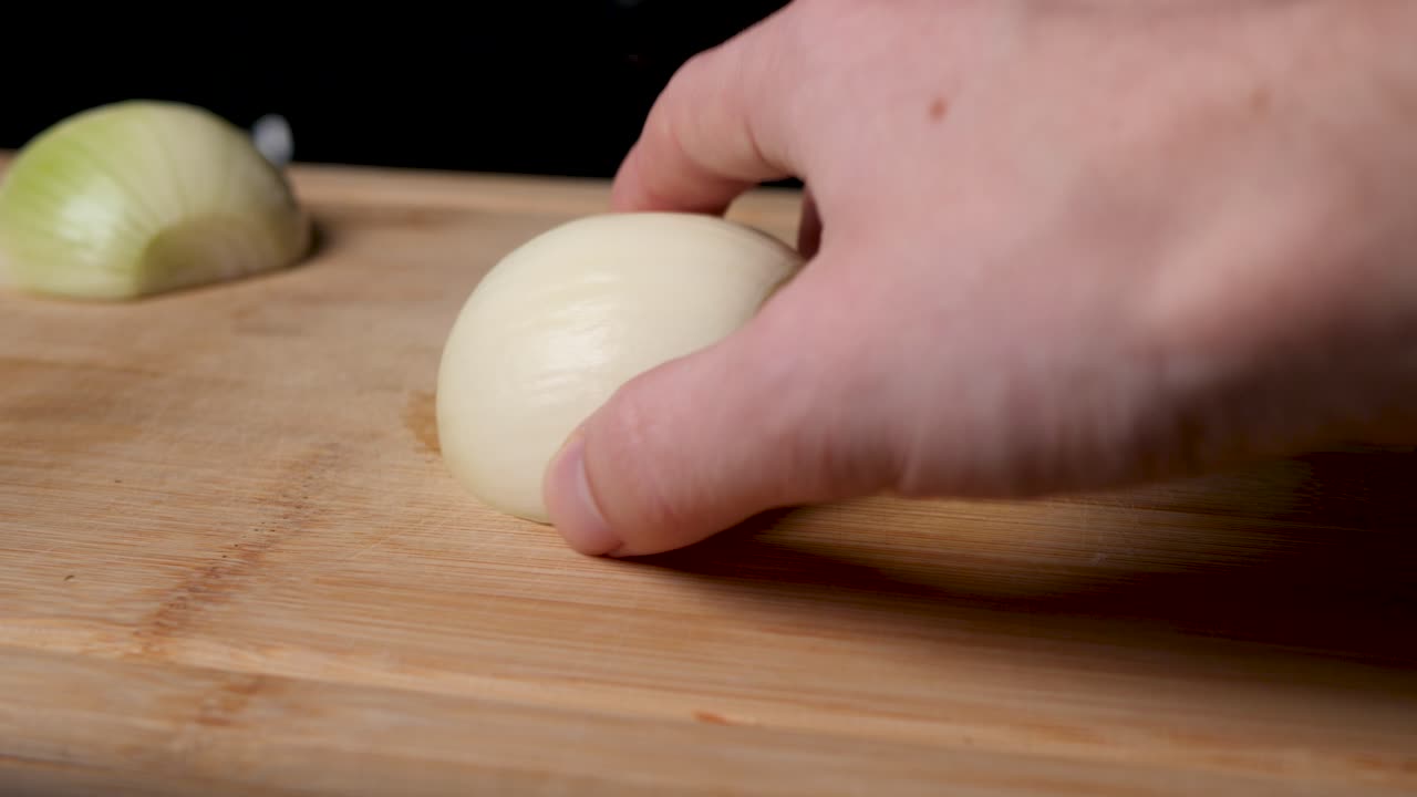 Cutting onion on a wooden cutting board