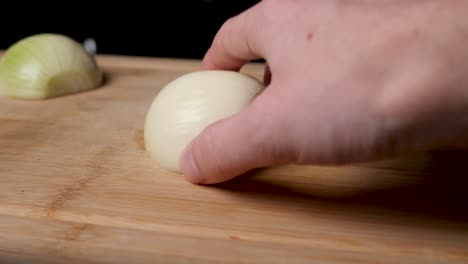 cutting onion on a wooden cutting board