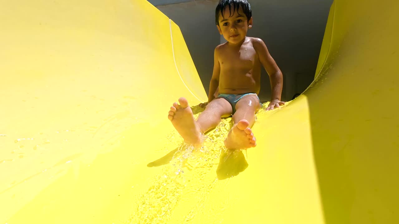 Niño divirtiéndose en un tobogán acuático