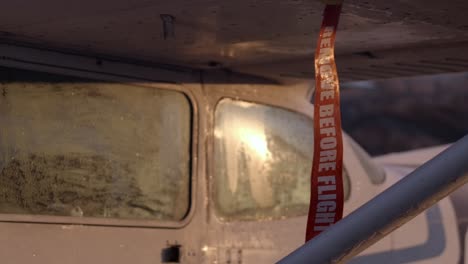 remove before flight tag on iced-up airplane exterior - golden hour