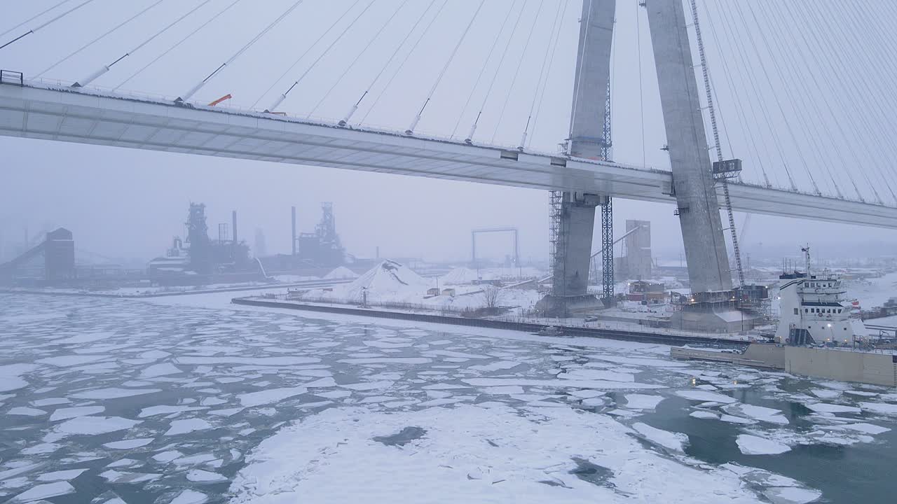 Tilt up video revealing Gordie Howe Bridge on foggy winter morning