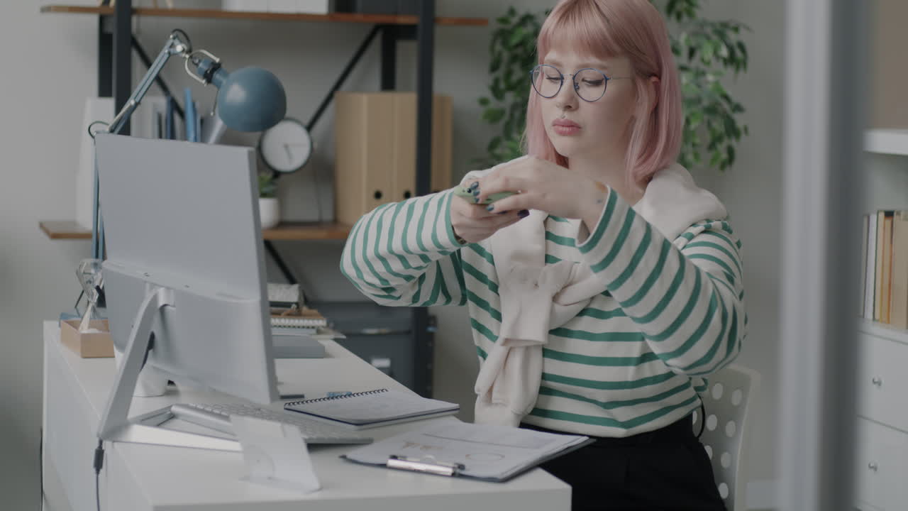 Woman Working on Computer and Phone in Office