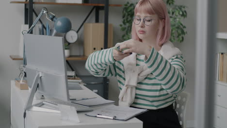 woman working on computer and phone in office