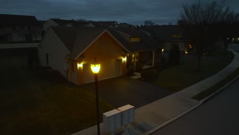 aerial orbit around street light revealing small american home at night