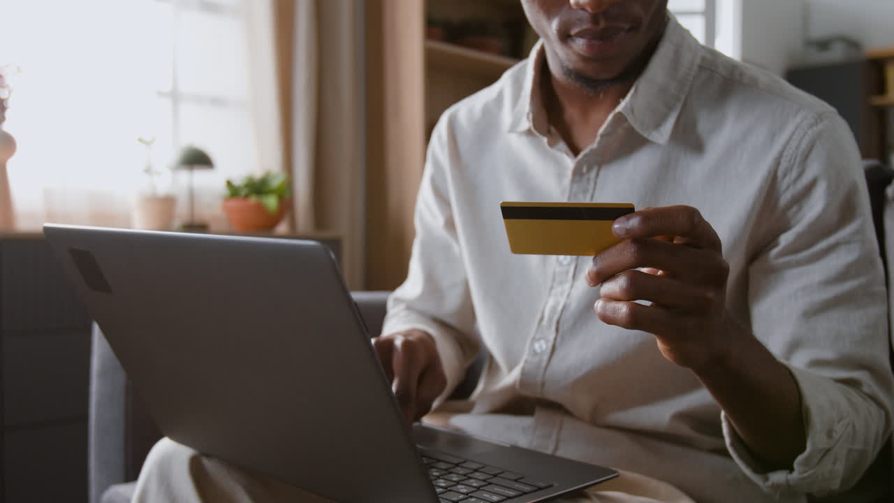 Man using credit card for online shopping on laptop