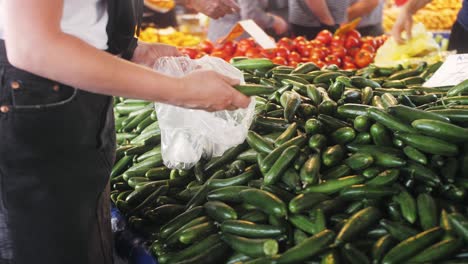 woman buying cucumbers at a market