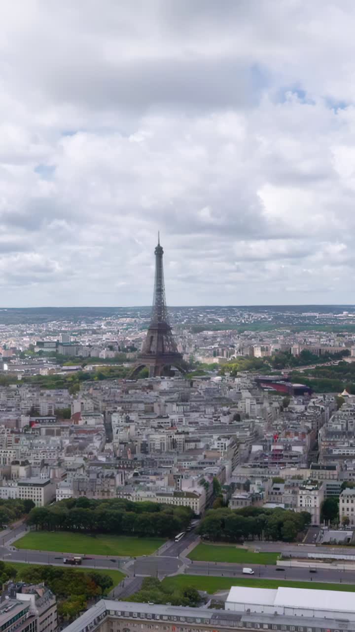 Splendida ripresa aerea verticale con drone che vola verso la Torre Eiffel che si erge su Parigi, con il fiume Senna che serpeggia attraverso lo skyline storico della città.