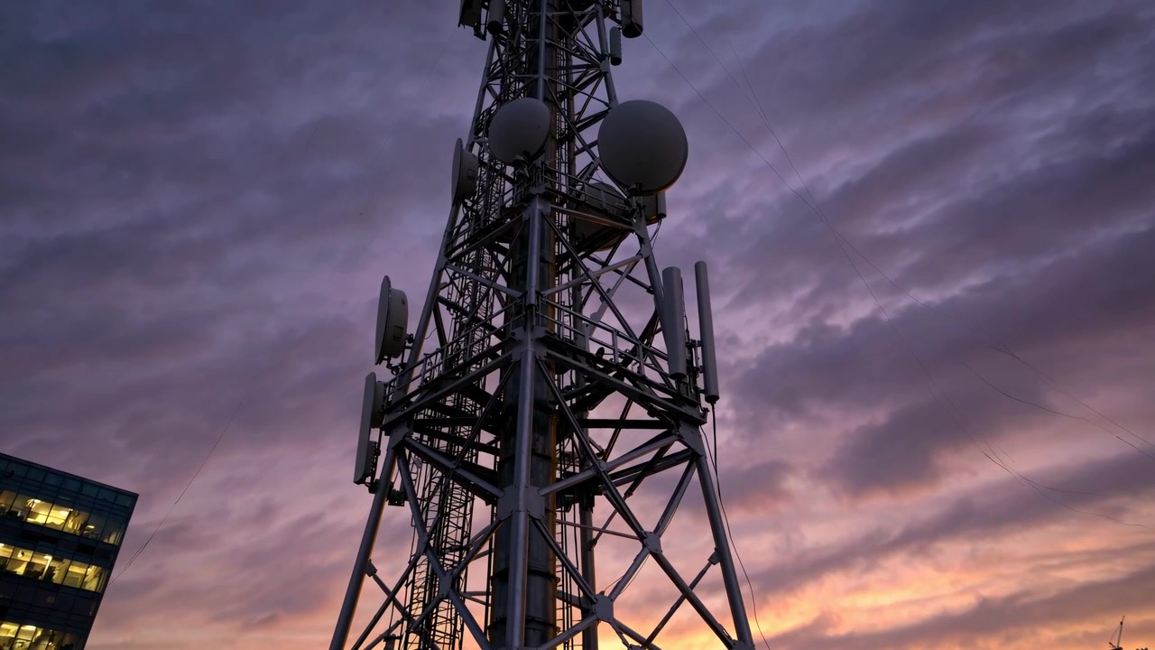 Moderna torre di telecomunicazioni contro un cielo serale colorato