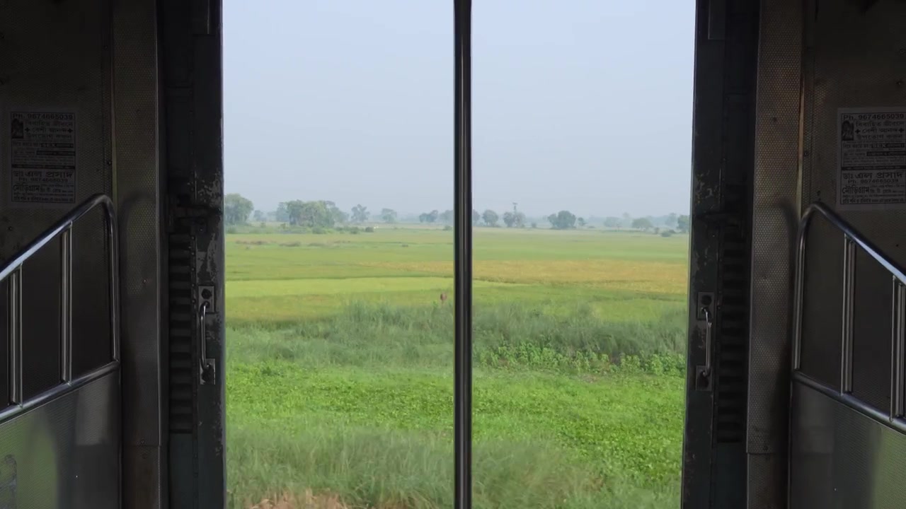 Udsigten udenfor fra et vindue eller en dør inde i toget.
