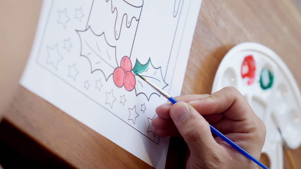 Close up of hand painting using watercolor to coloring sheet