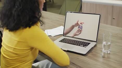 Mujer-Birracial-En-La-Mesa-Usando-Laptop,-Compras-En-Línea-De-Productos-De-Belleza,-Cámara-Lenta