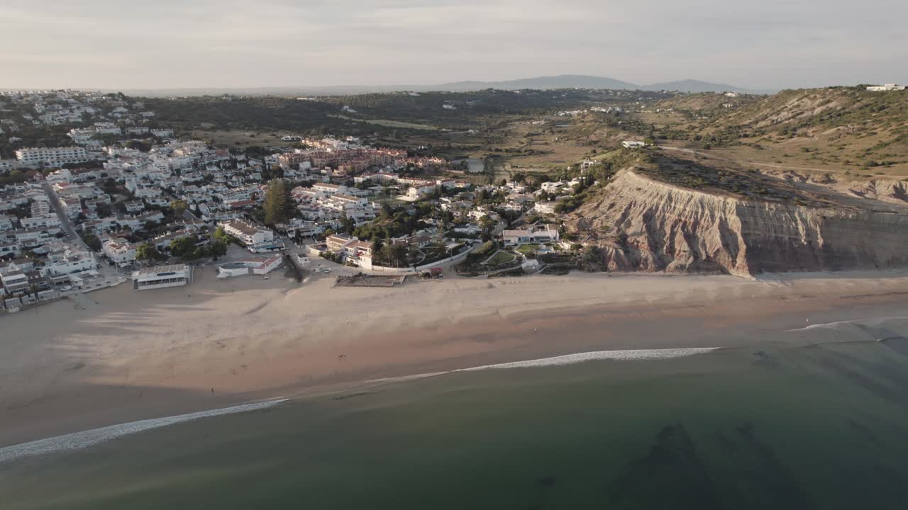 amplia vista sobre la desierta praia da luz en la costa del algarve al atardecer