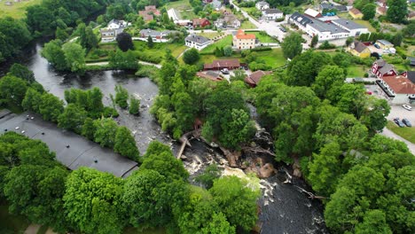 laxens hus by morruman river in morrum, sweden with lush greenery and cascading waters, aerial view