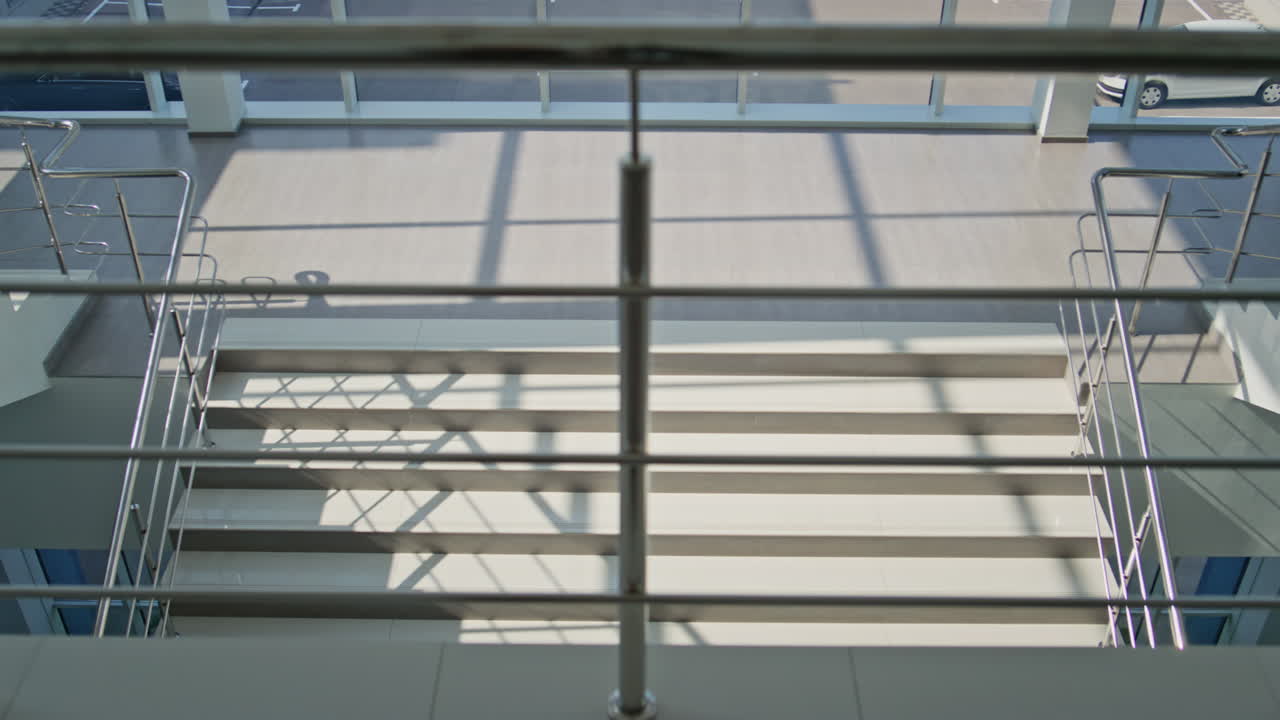 Successful employee going downstairs modern sunlit office. Confident businessman