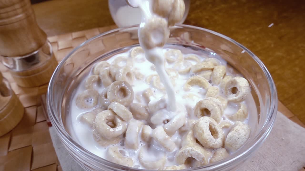 우유와 함께 맛있는 아침 식사를 위해 그 ⁇ 에  ⁇ 한 오트 플레이크. 회전 추적 촬영과 함께 느린 동작.