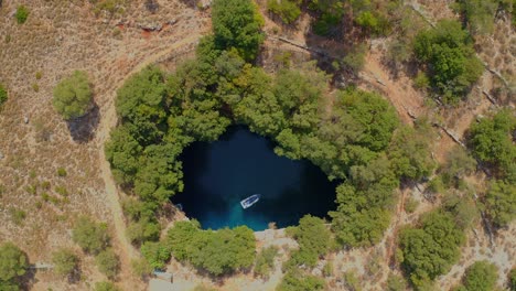 Vista-Aérea-De-Arriba-Hacia-Abajo-En-Barco-Cruzando-El-Lago-En-La-Cueva-De-Melissani,-Hermoso-Paisaje