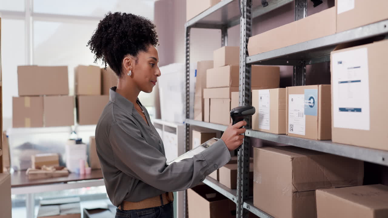Woman Scanning Packages with Barcode Scanner and Tablet in Warehouse