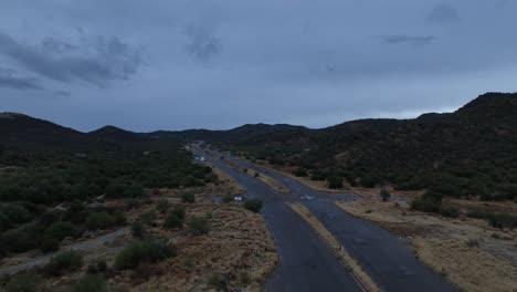 aerial-shot-of-drone-flying-over-road-or-highway-in-cloudy-day