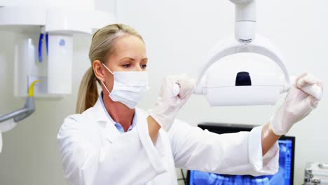 female dentist adjusting dental lights