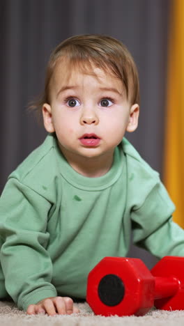 young infant baby having fun at home. small cute child playing with toys. vertical video