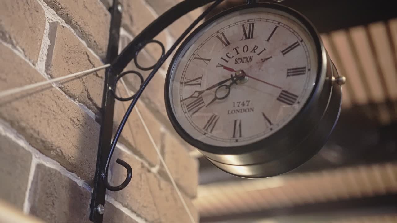 A beautiful retro clock hangs on the wall in the bar. Cool interior decoration. Close up
