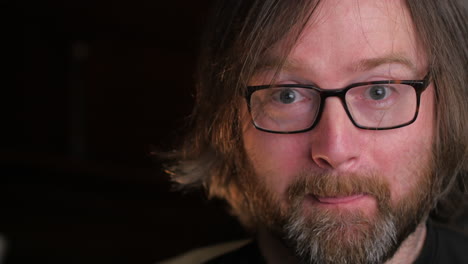 excited look of bearded man with black background , close up