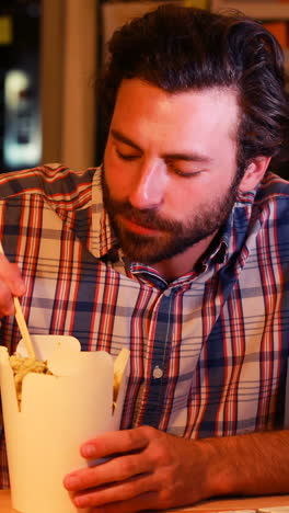 business executive using digital tablet while having chinese food