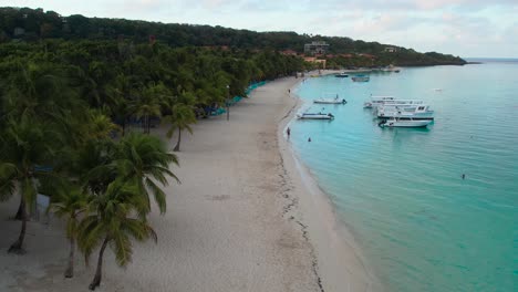 Vista-Aérea-Cinematográfica-De-La-Costa-Caribeña,-Agua-Turquesa,-Playa-De-Arena-Durante-El-Amanecer,-Isla-De-Roatán,-Extremo-Oeste,-Honduras