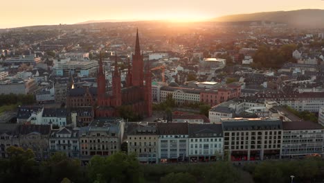envolviendo la marktkirche en wiesbaden alemania con un dron en la noche justo antes del atardecer mostrando el casco antiguo y el centro de la ciudad