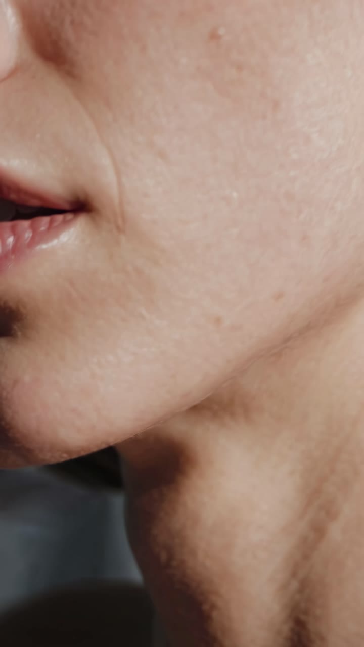 Close-up video angle capturing a woman's cheek and ear, highlighting skin texture and natural beauty
