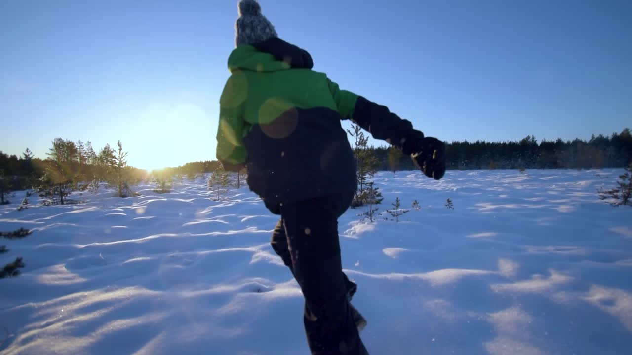 corriendo por un paisaje cubierto de nieve mientras la nieve comienza a volar