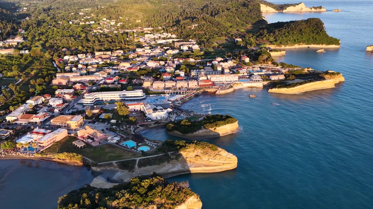 Kuzey Korfu Yunanistan'da Gün Batımında Sidari Kasabası ve Sahil Şeridi'nin Havadan Görünümü - Avrupa Yaz Tatil Köyü, Kumlu Plajlar ve İyon Denizi'nin Drone Çekimi.