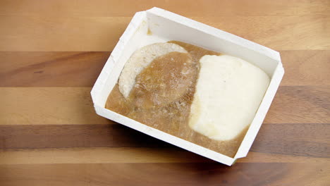 caja de comida congelada empacada que se arroja sobre la mesa y se agarra con hambre