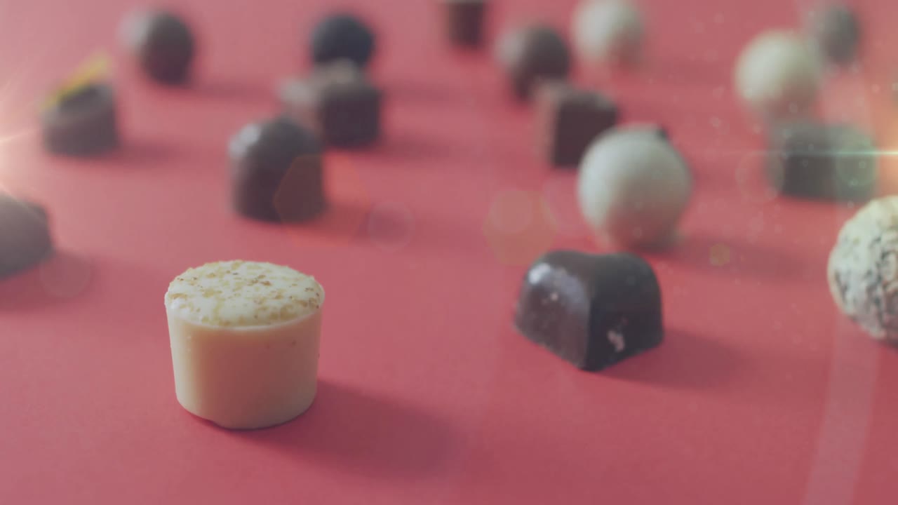 animación de la luz sobre pralinas de chocolate en superficie roja