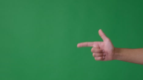 haciendo un gesto de tiro con la mano sobre un fondo verde