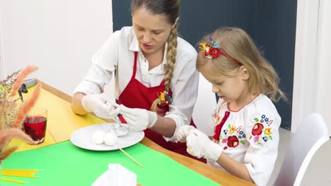 mother and daughter decorating easter eggs