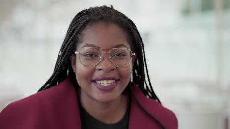 Medium-shot-of-Afro-American-attractive-young-girl-with-plump-rose-lips-and-braids-in-aviator-eyeglasses-wearing-rose-coat