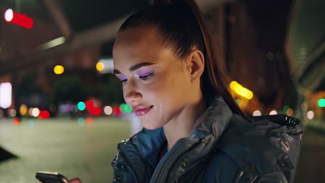 Woman-watching-media-content-on-smartphone-at-night-city-close-up.-Evening-town