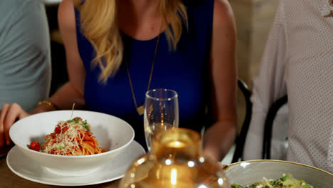 friends interacting with each other on dinner table in the restaurant 4k 4k