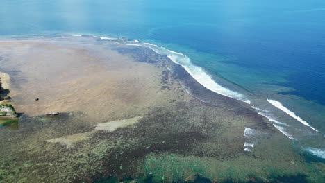 stunning aerial dolly shot of coastal shallow reef with turquoise ocean waves crashing at catanduanes, philippines