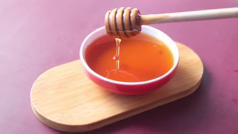 honey dripping from dipper into bowl