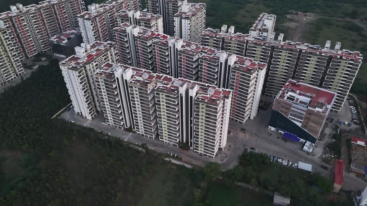 Aerial footage captures a massive residential complex of modern apartment buildings. a high-density urban development with multiple high-rises, large-scale real estate and housing projects