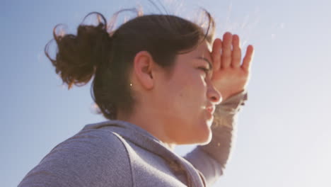 Mujer-Caucásica-Sosteniendo-Una-Estera-Deportiva-Rosa-En-La-Playa-Y-Fondo-De-Cielo-Azul