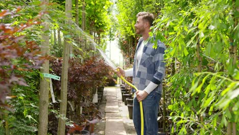 man watering plants in garden